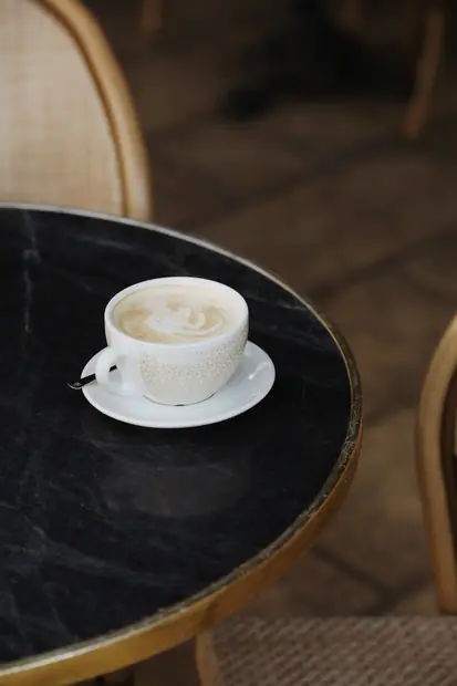 Un cappuccino servi sur un guéridon de marbre