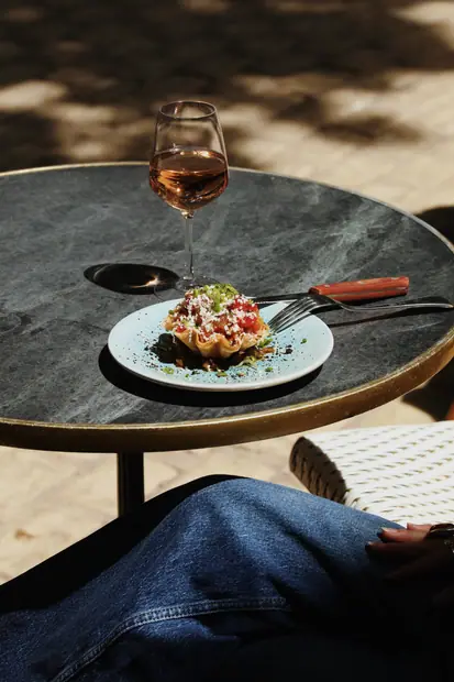 Assiette servie sur un guéridon de marbre, en terrasse
